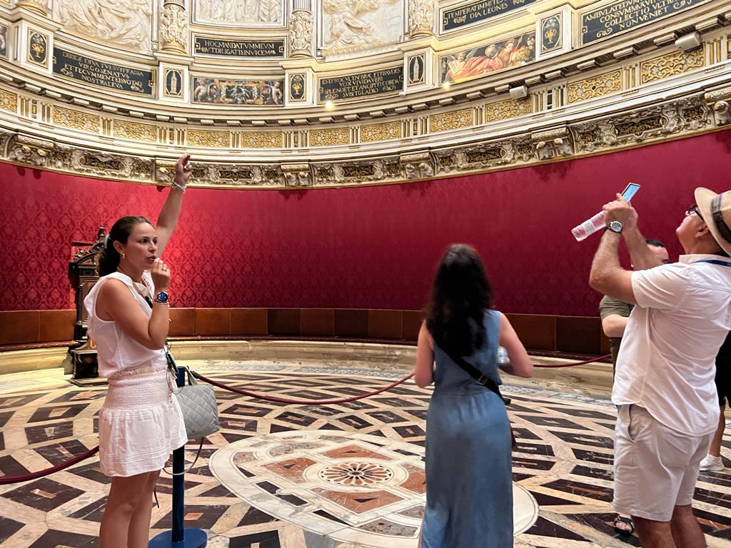 Mujeres en una sala roja con mármoles en las paredes